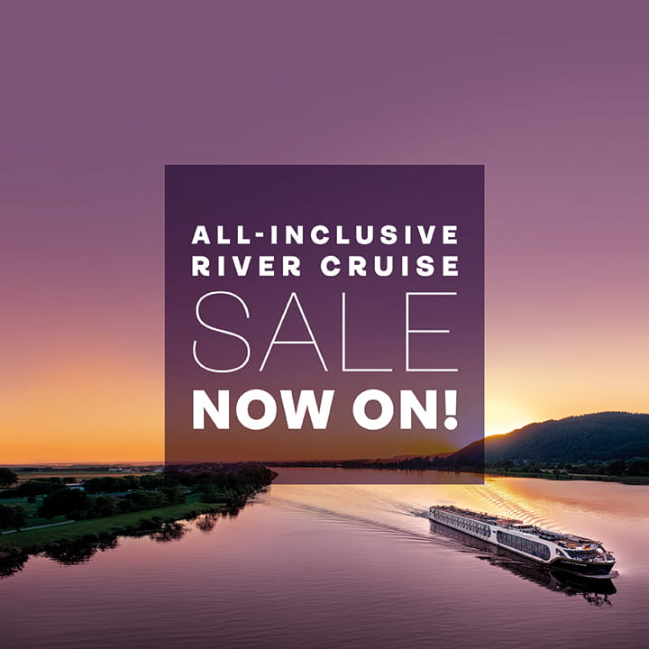 White 'all-inclusive river cruise sale now on' text in a purple square overlaid on an image of Spirit of the Danube sailing at sunset